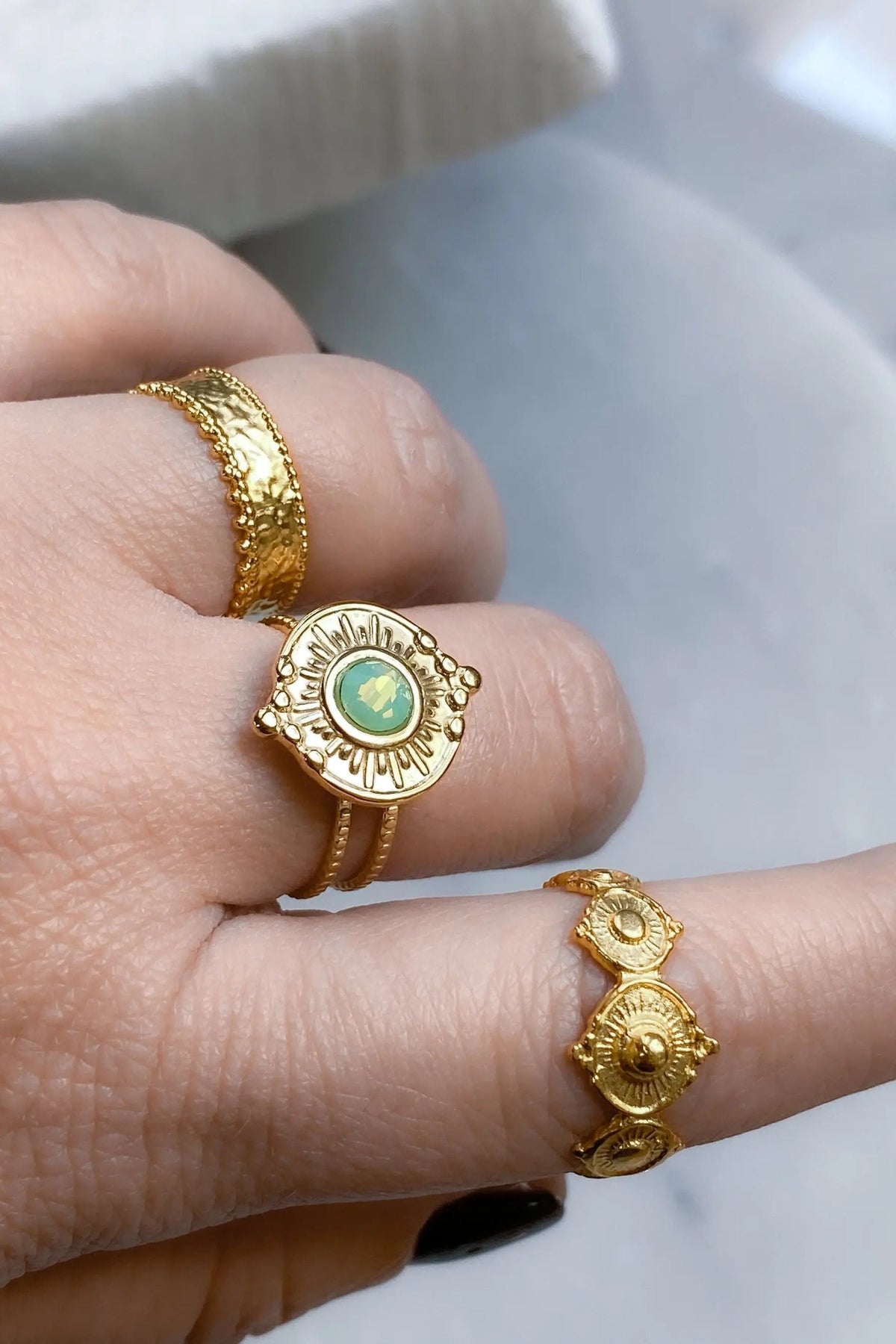 SEZAN Gold Stone Ring with a gold-toned textured band and round green stone in an ornate sunburst setting