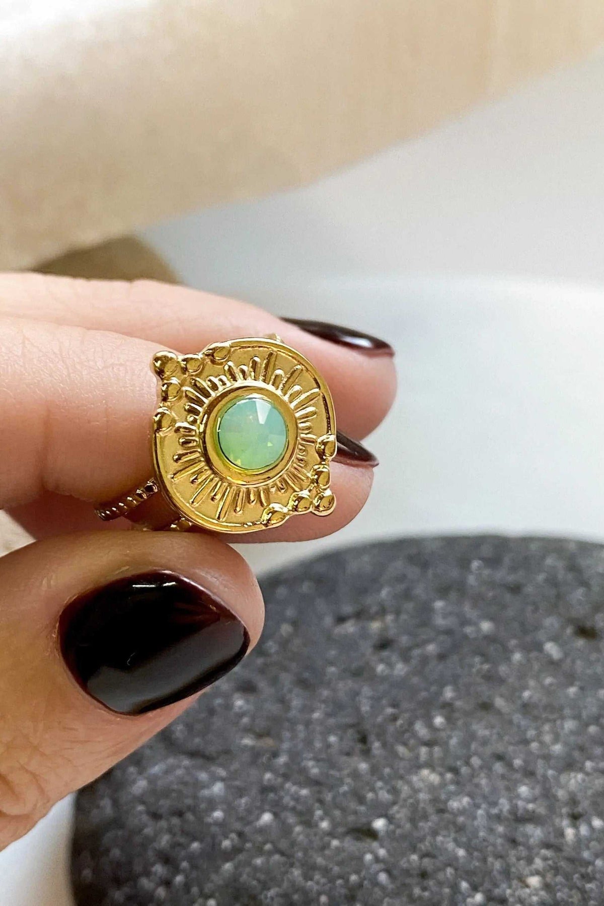 SEZAN Gold Stone Ring with a round green crystal in an ornate, sunburst-patterned gold-tone setting.