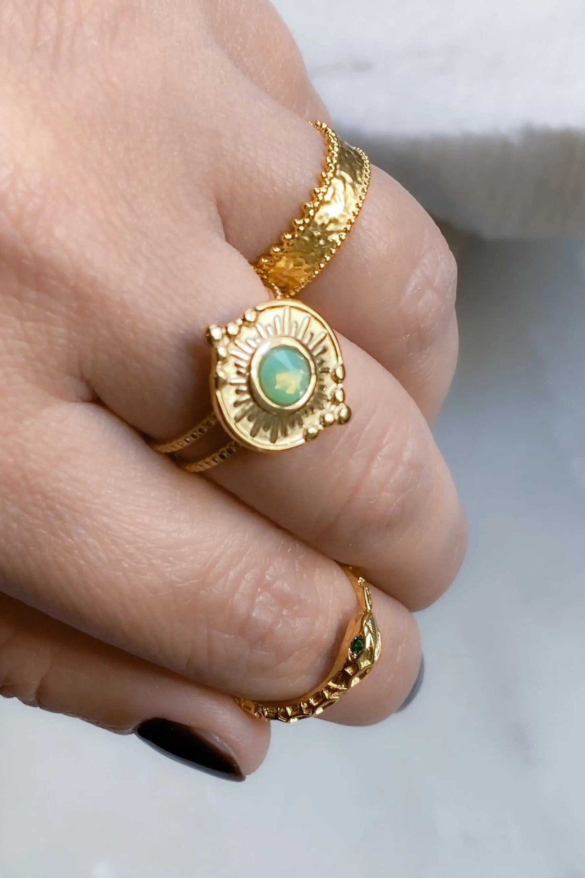 SEZAN Gold Stone Ring with an ornate gold-tone band, round sunburst setting and oval pale green stone