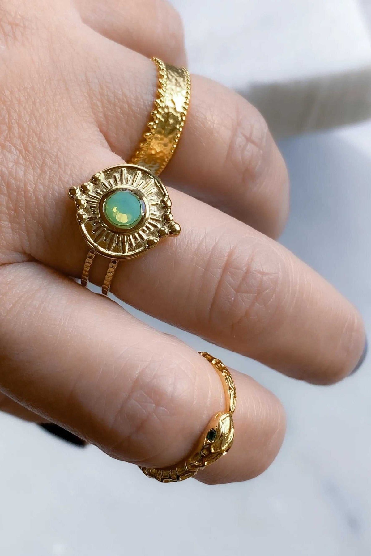 SEZAN Gold Stone Ring, textured gold-tone bands with a round green stone in an ornate sunburst setting