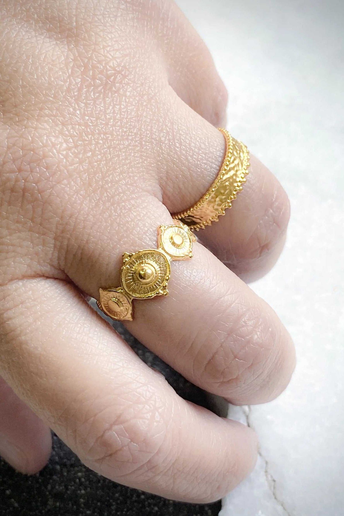 SHARMA Dotted gold ring, ornate gold-tone ring with raised dotted texture and circular geometric details worn on a finger