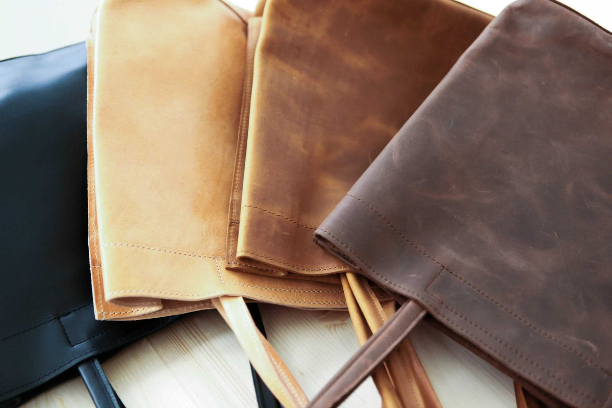shoppers bag in smooth full-grain leather, shown in black, natural, cinnamon and dark brown with long handles