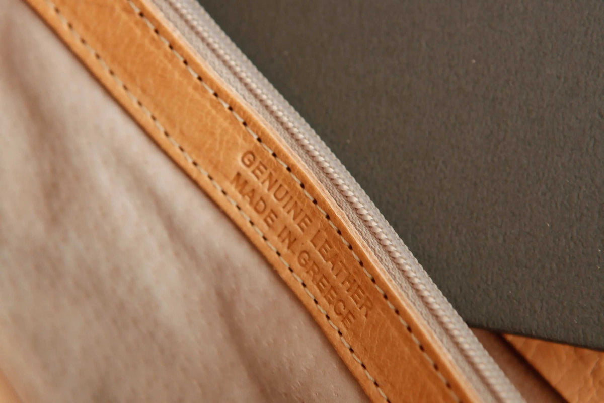 shoppers bag detail in natural full-grain leather, showing a stitched edge, zipper and embossed handmade-in-Greece mark