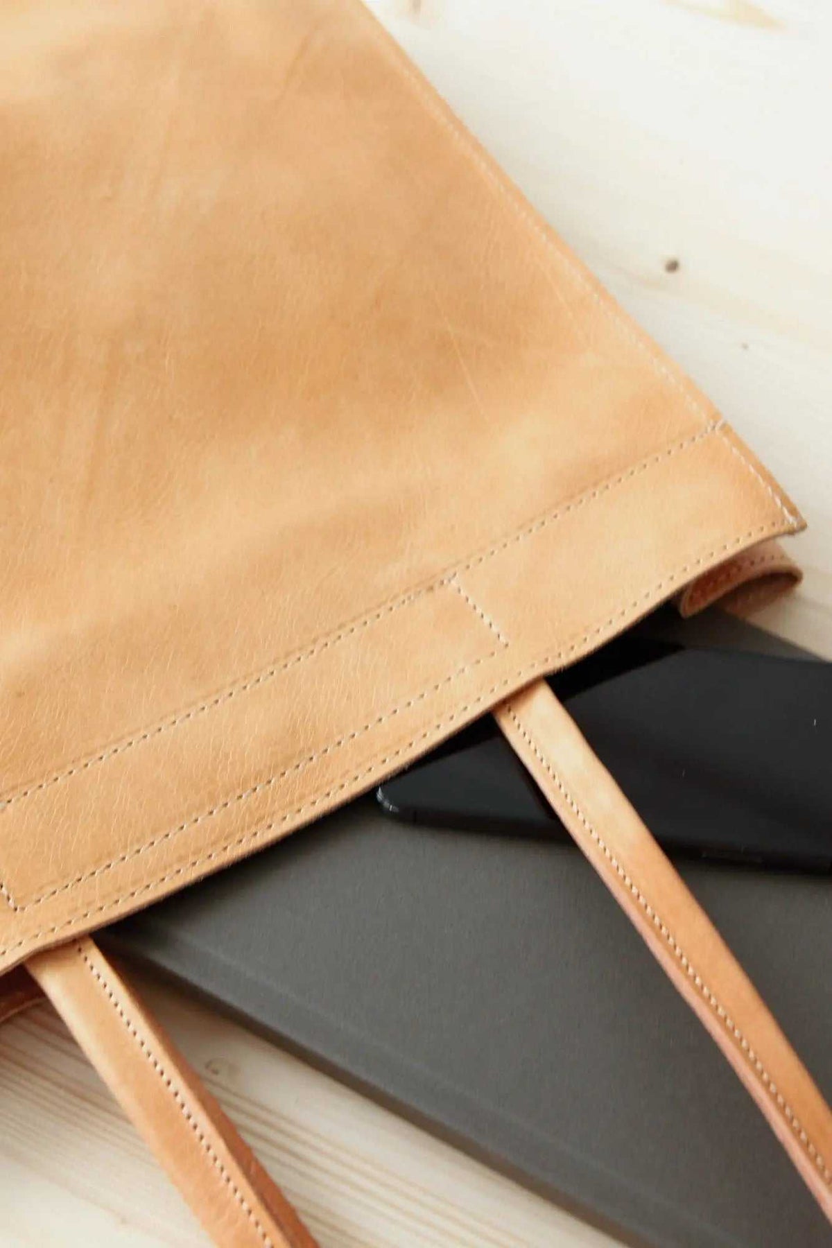 shoppers bag in natural tan full-grain leather with long handles and neat stitched edge detailing