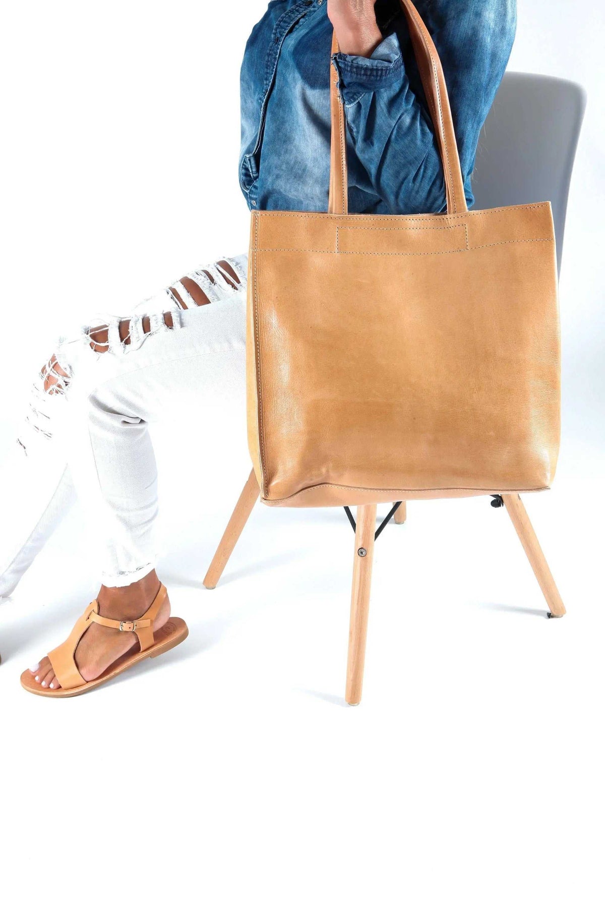 shoppers bag in natural tan full-grain leather with long shoulder handles and a minimalist rectangular design