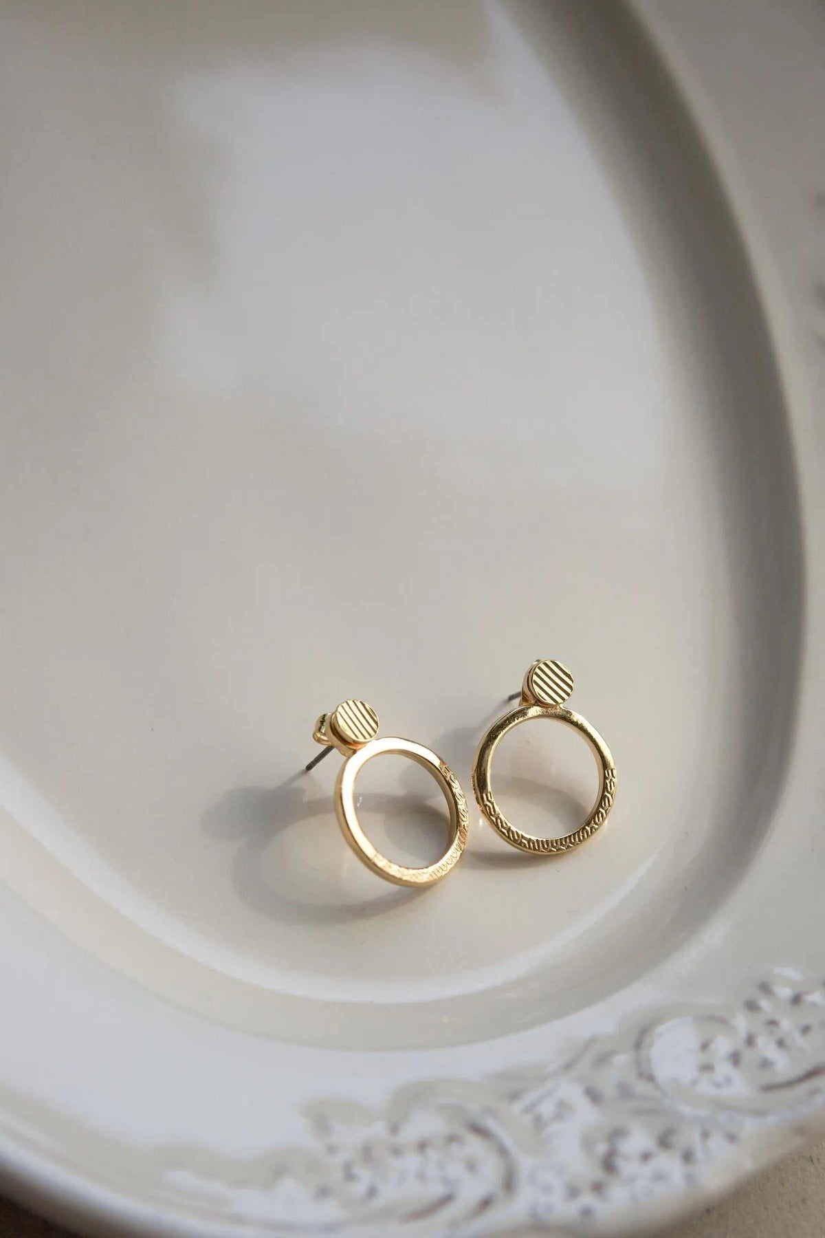 Small Stripe patterned Hoops in gold-plated brass with diagonal striped circular charms and titanium pins