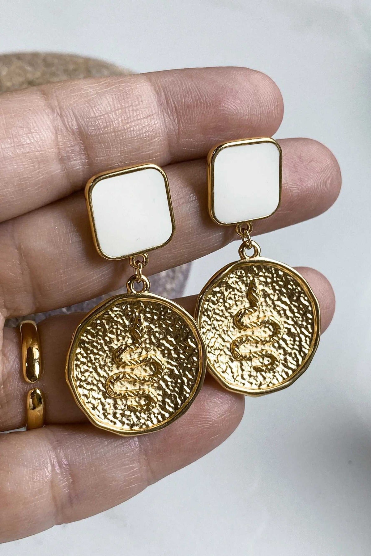 SNAKE Gold Coin Earrings with gold-tone textured snake medallions and white square resin studs