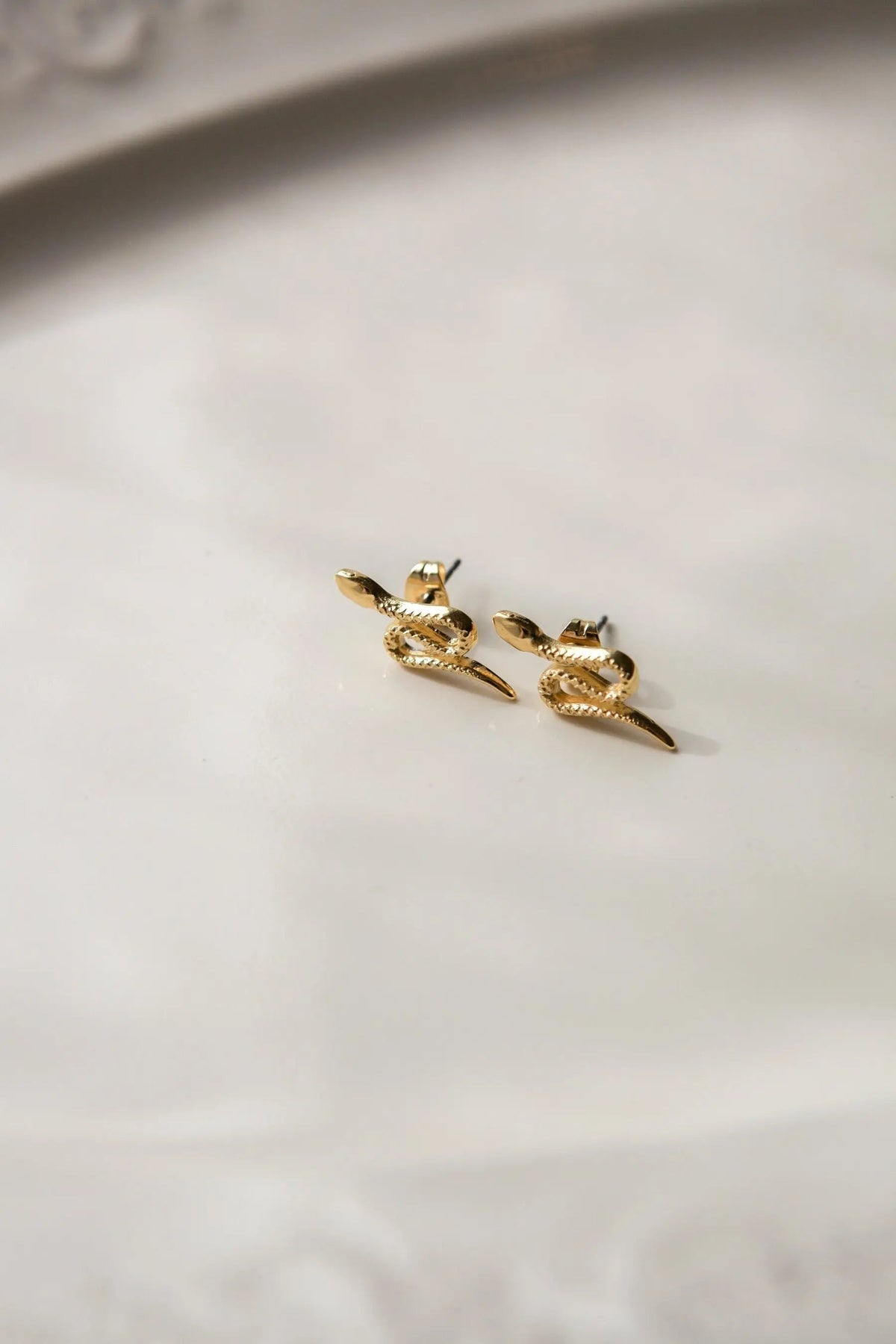 Snake gold earrings in bright gold-tone metal, shaped as coiled snakes with textured scales and pointed tails