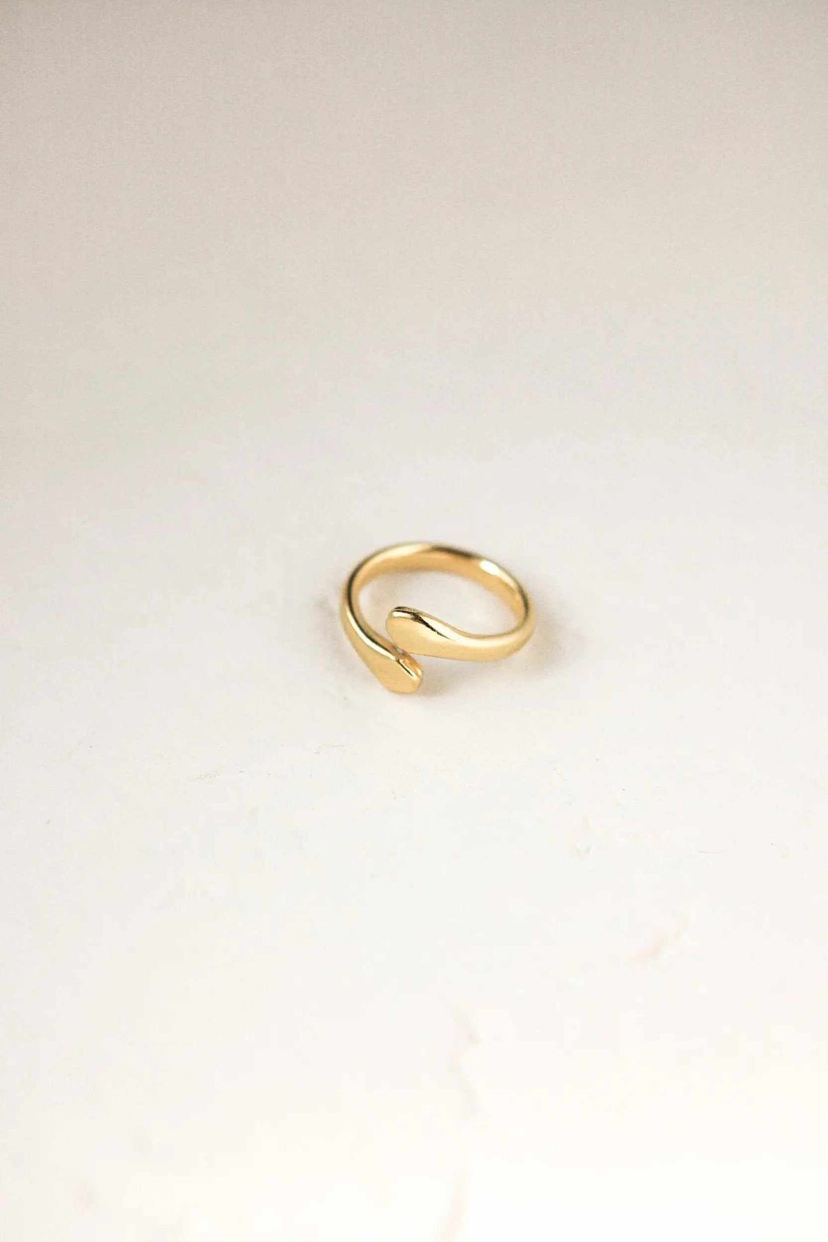 Snake Wrap RING in smooth polished gold-tone metal, formed as a minimalist open loop with tapered ends