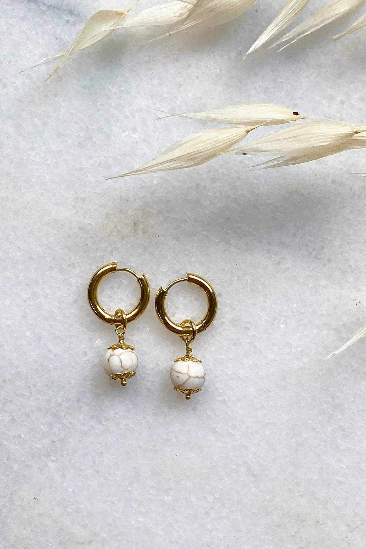 SORAYA medium earrings, gold huggie hoops with dangling white marbled gem charms and gold detailing