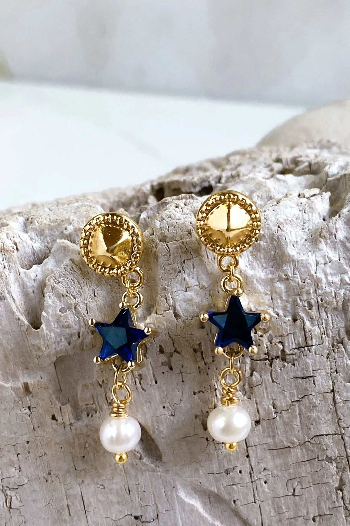 STAR dangle drop earrings with dark blue star charms, gold-toned textured discs and white pearl drops