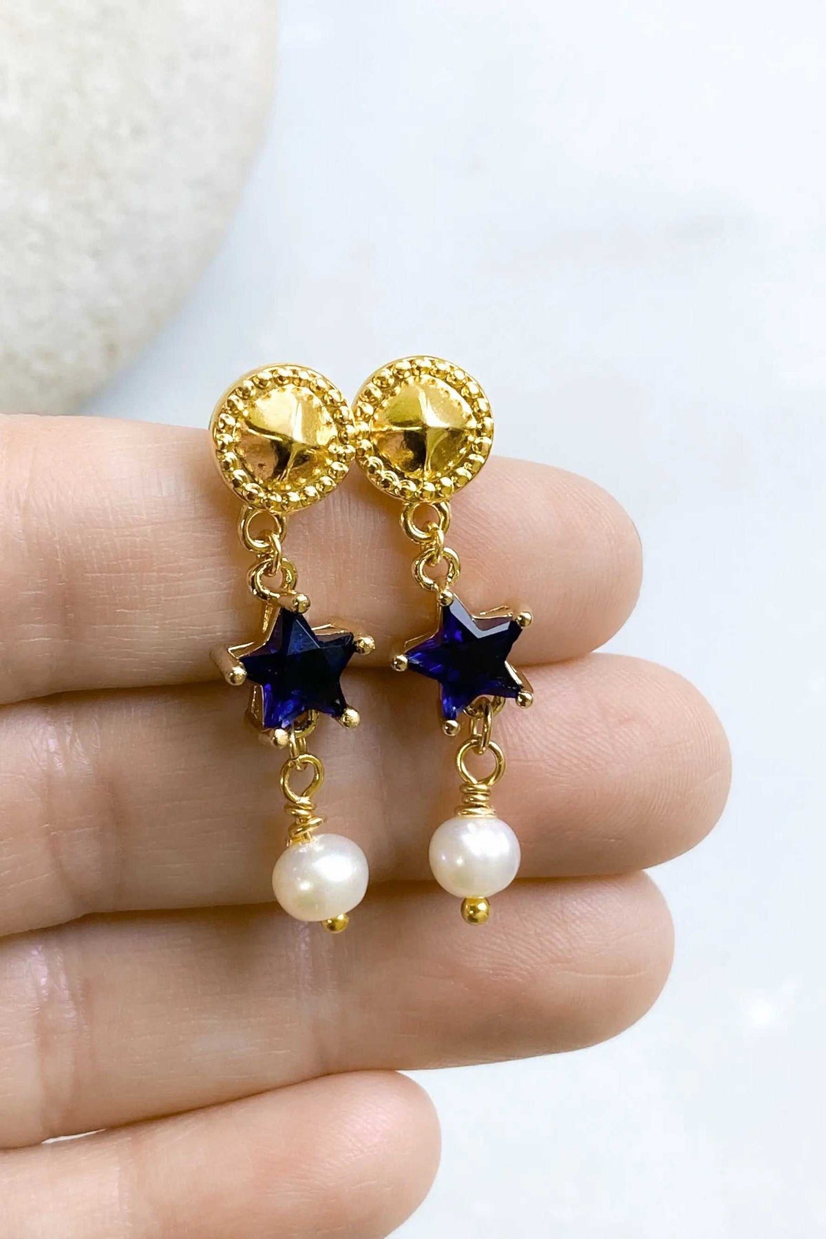 STAR dangle drop earrings with gold-tone textured studs, deep blue star-shaped stones, and dangling white pearls