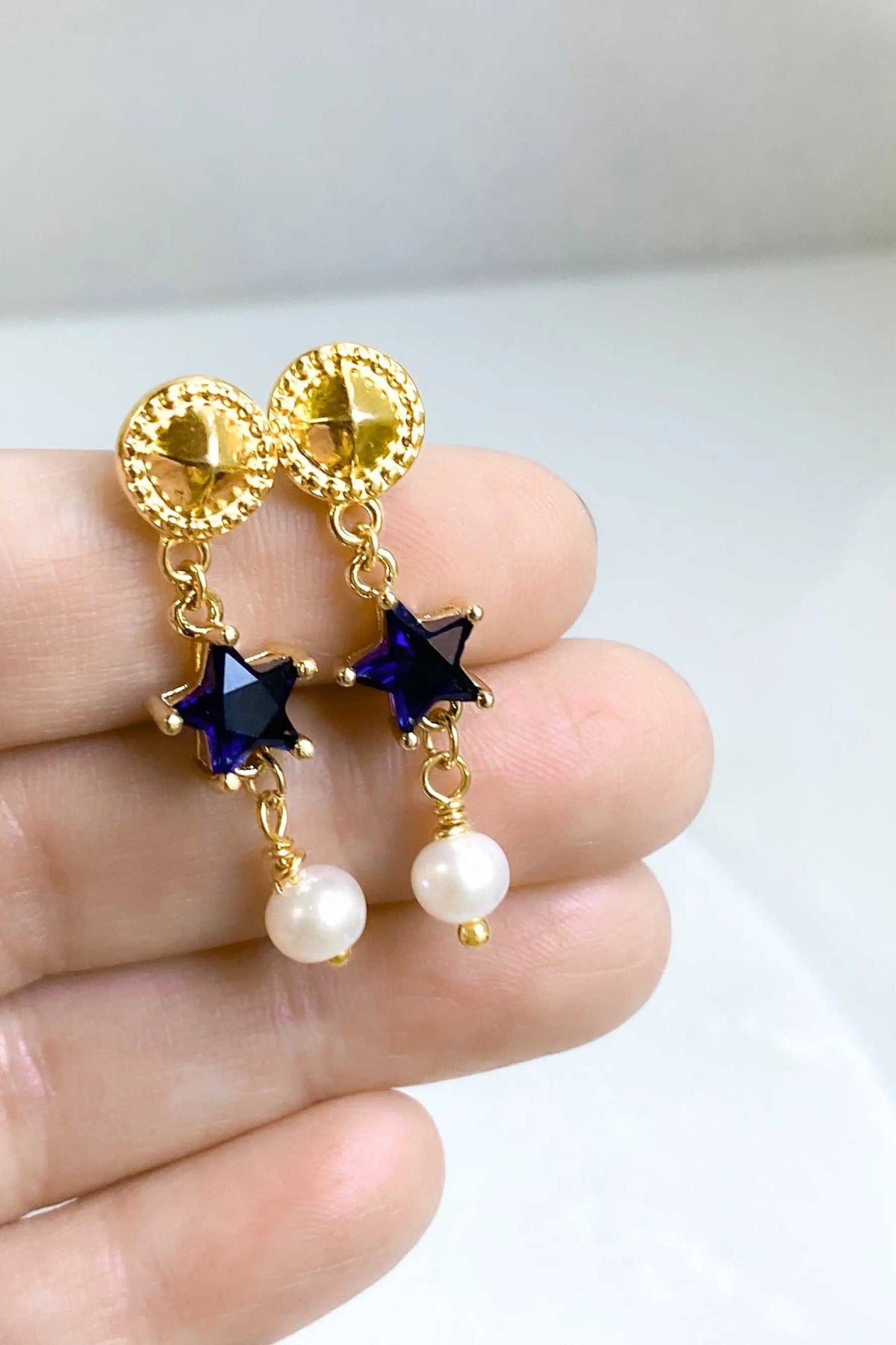 STAR dangle drop earrings with gold-tone textured studs, blue star charms and dangling white pearl beads