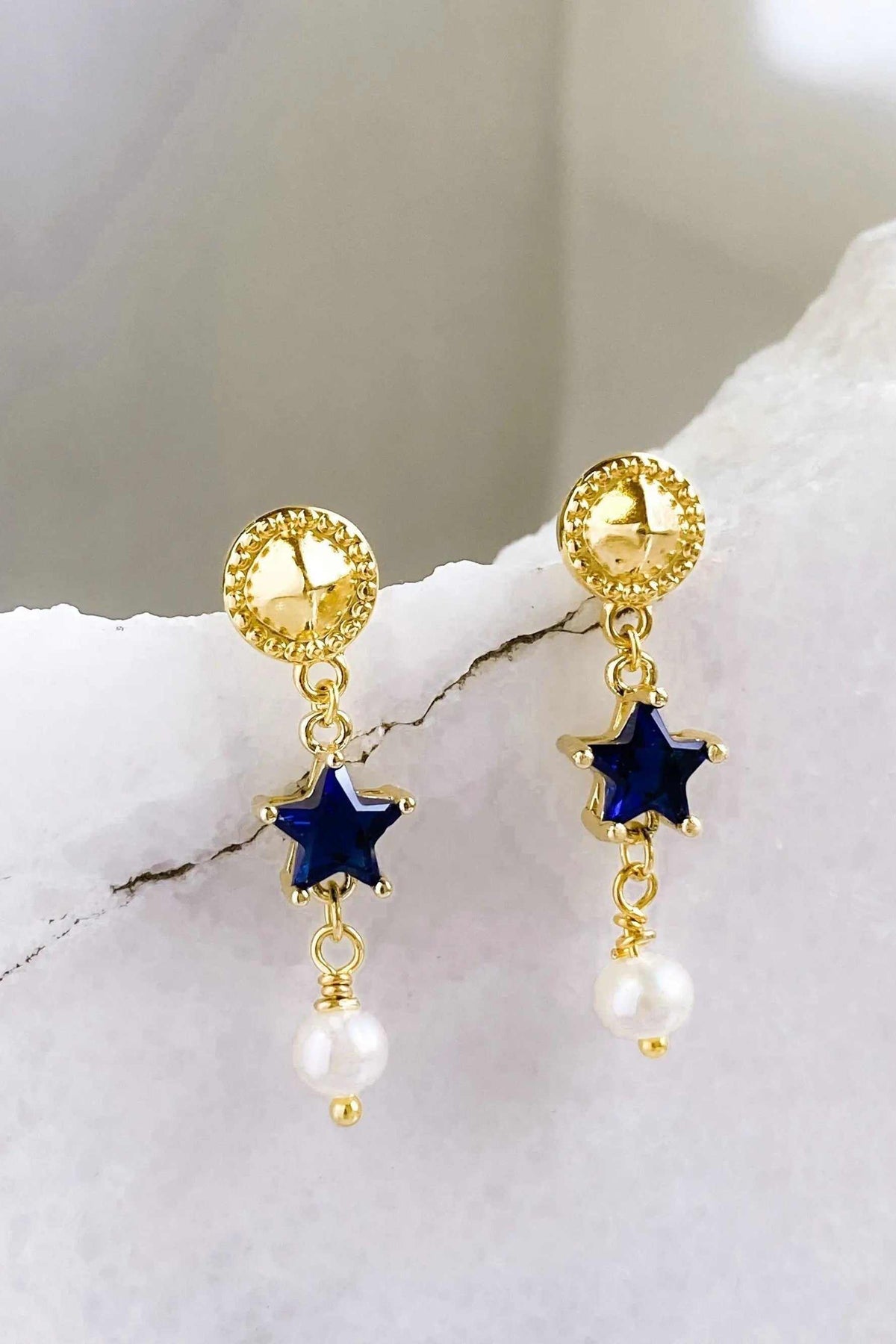 STAR dangle drop earrings in gold-tone metal with dark blue star charms and dangling white pearl beads