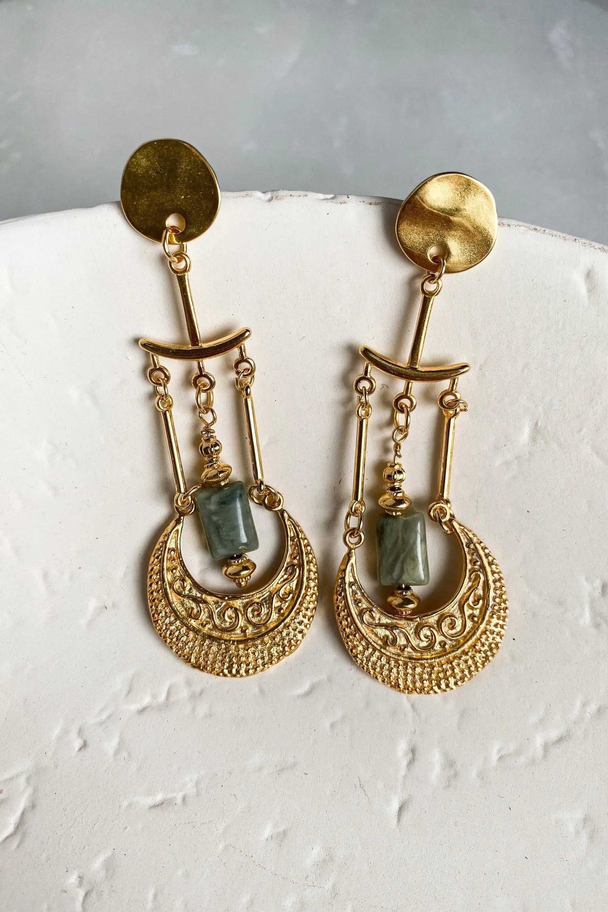 Statement Boho Earrings in gold-toned metal with rectangular green stones, dangling chains and ornate crescent drops