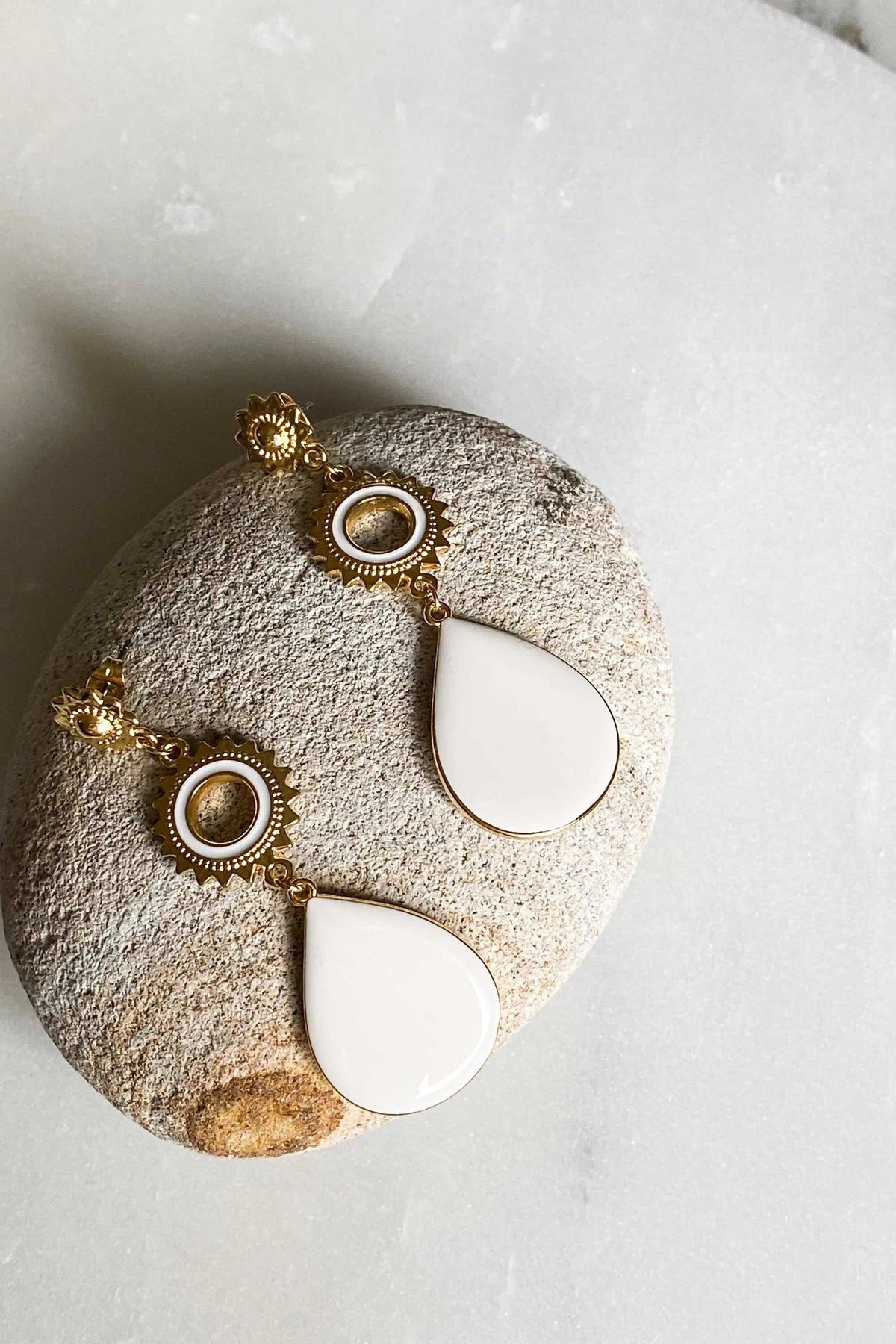 Statement Boho Earrings with gold-tone sunburst and beaded circular details, finished with smooth white enamel teardrops