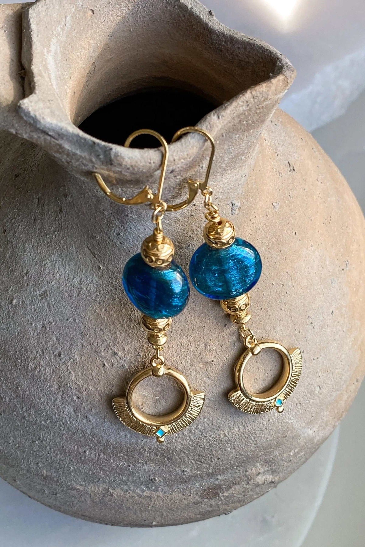 Statement Crystal Earrings with vivid blue glass beads, ornate gold-tone settings, and dangling circular charms with tiny turquoise stones