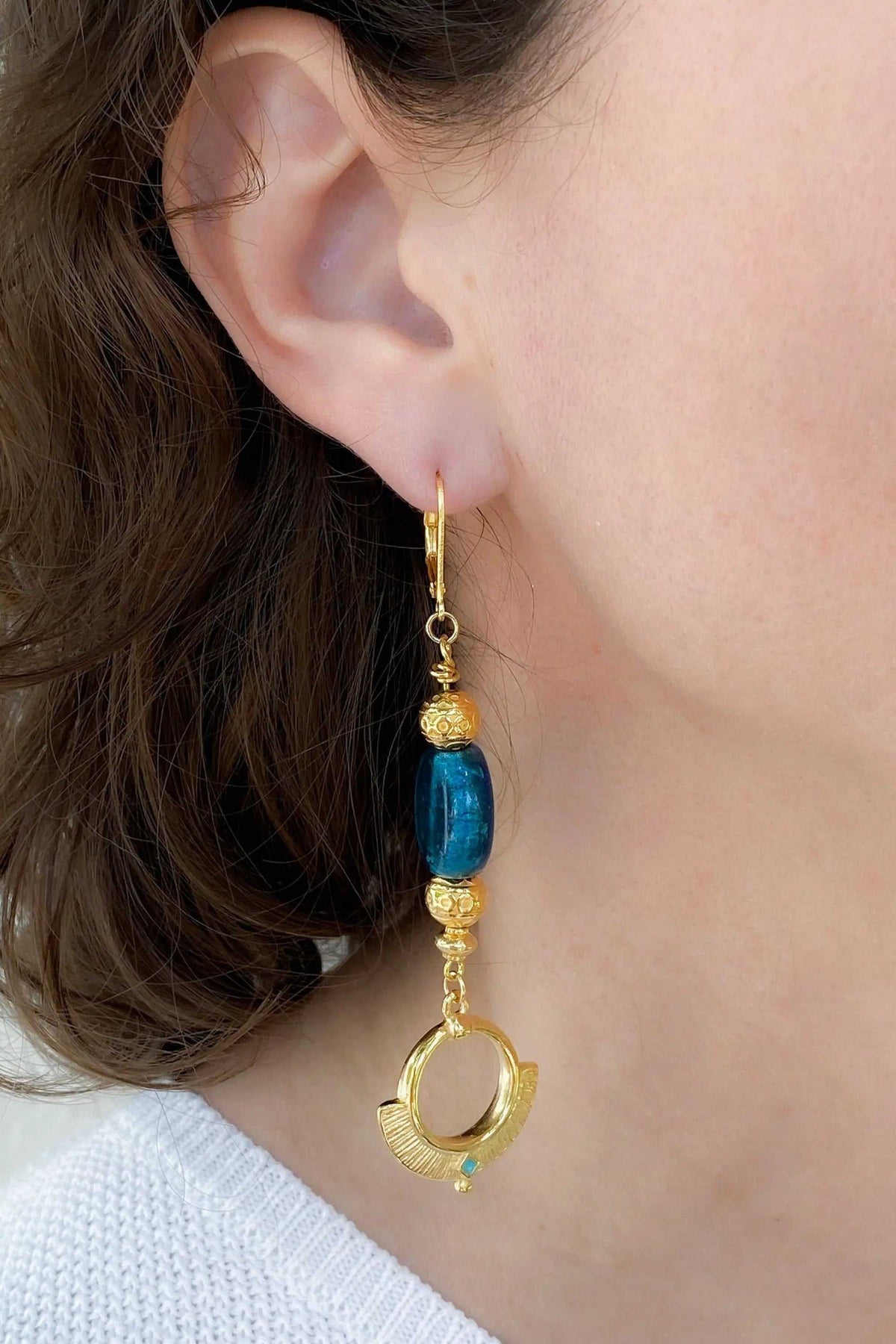 Statement Crystal Earrings with a vivid blue glass bead, ornate gold-toned accents and a circular drop charm
