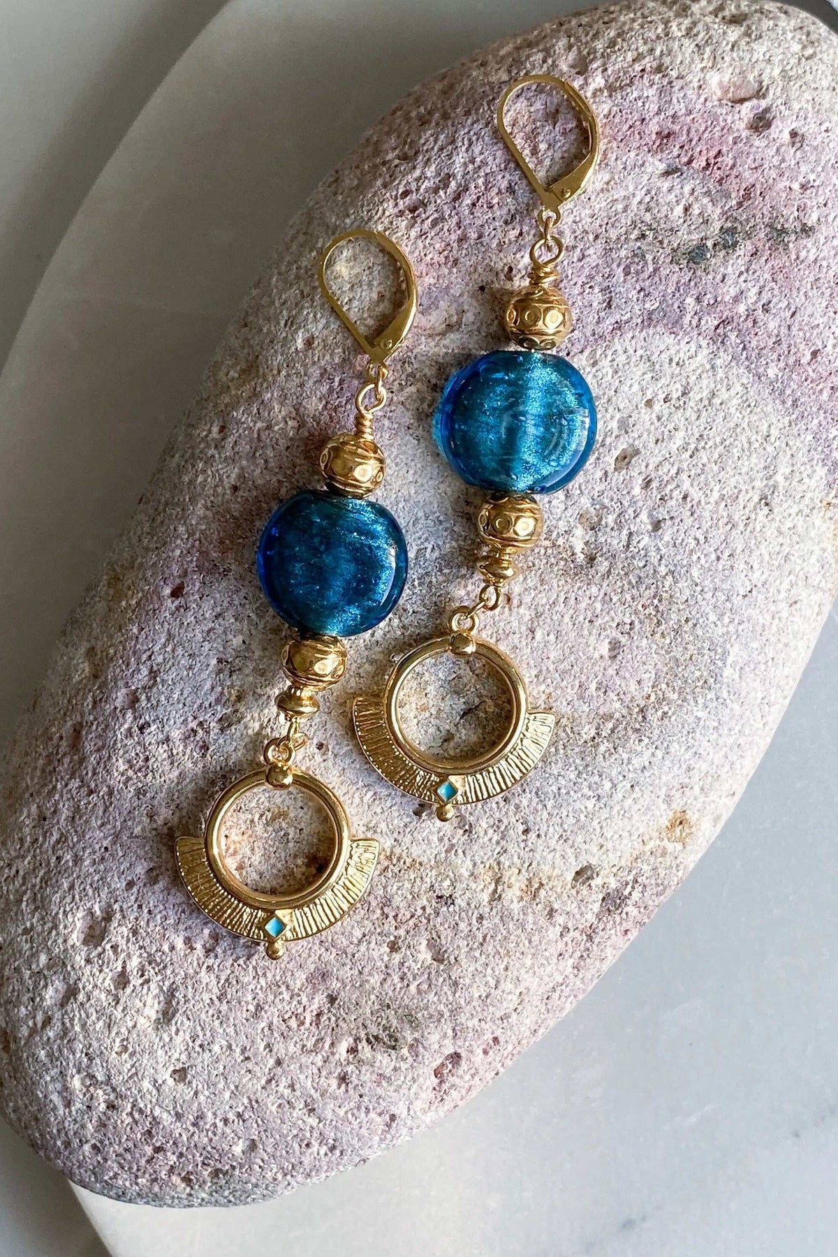 Statement Crystal Earrings with vivid blue glass stones, gold-tone textured brass links and open circular pendant drops.
