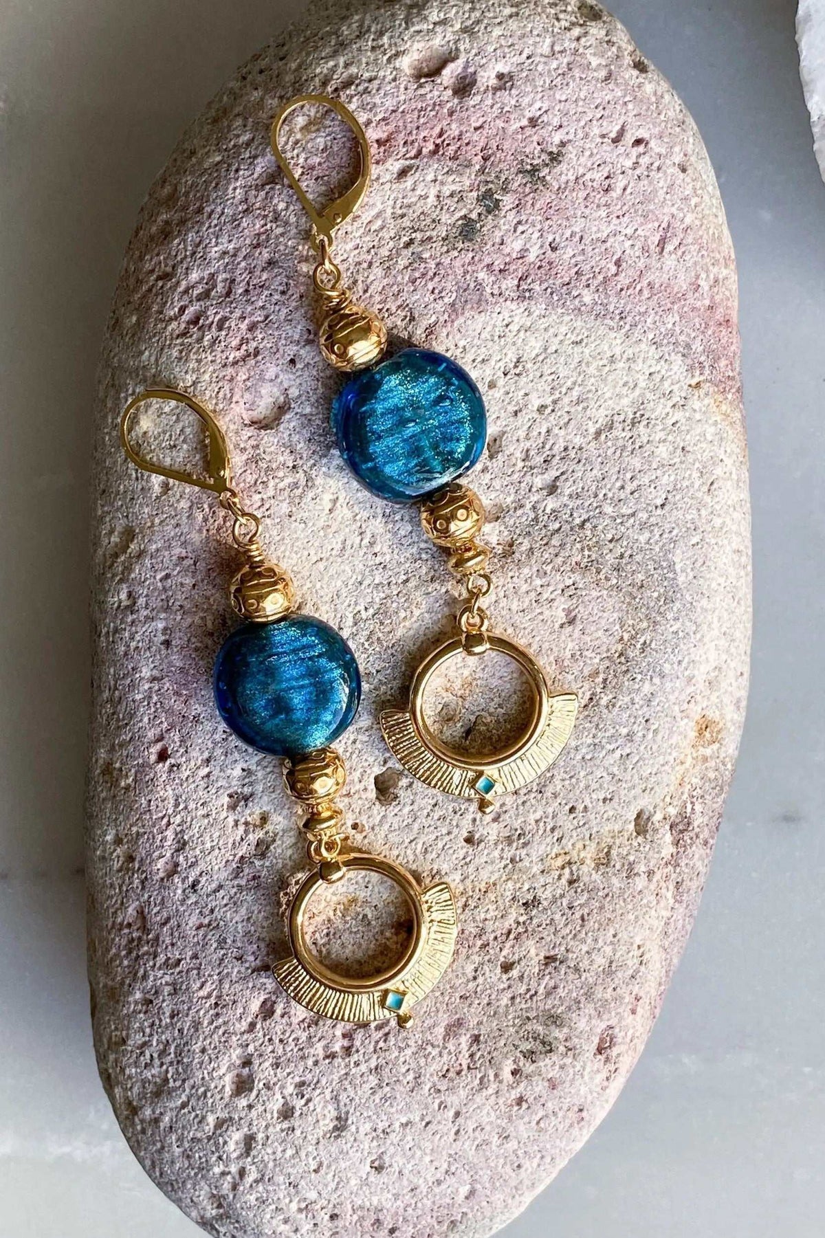 Statement Crystal Earrings in gold-tone metal with vivid blue round stones, textured beads and open circular drops