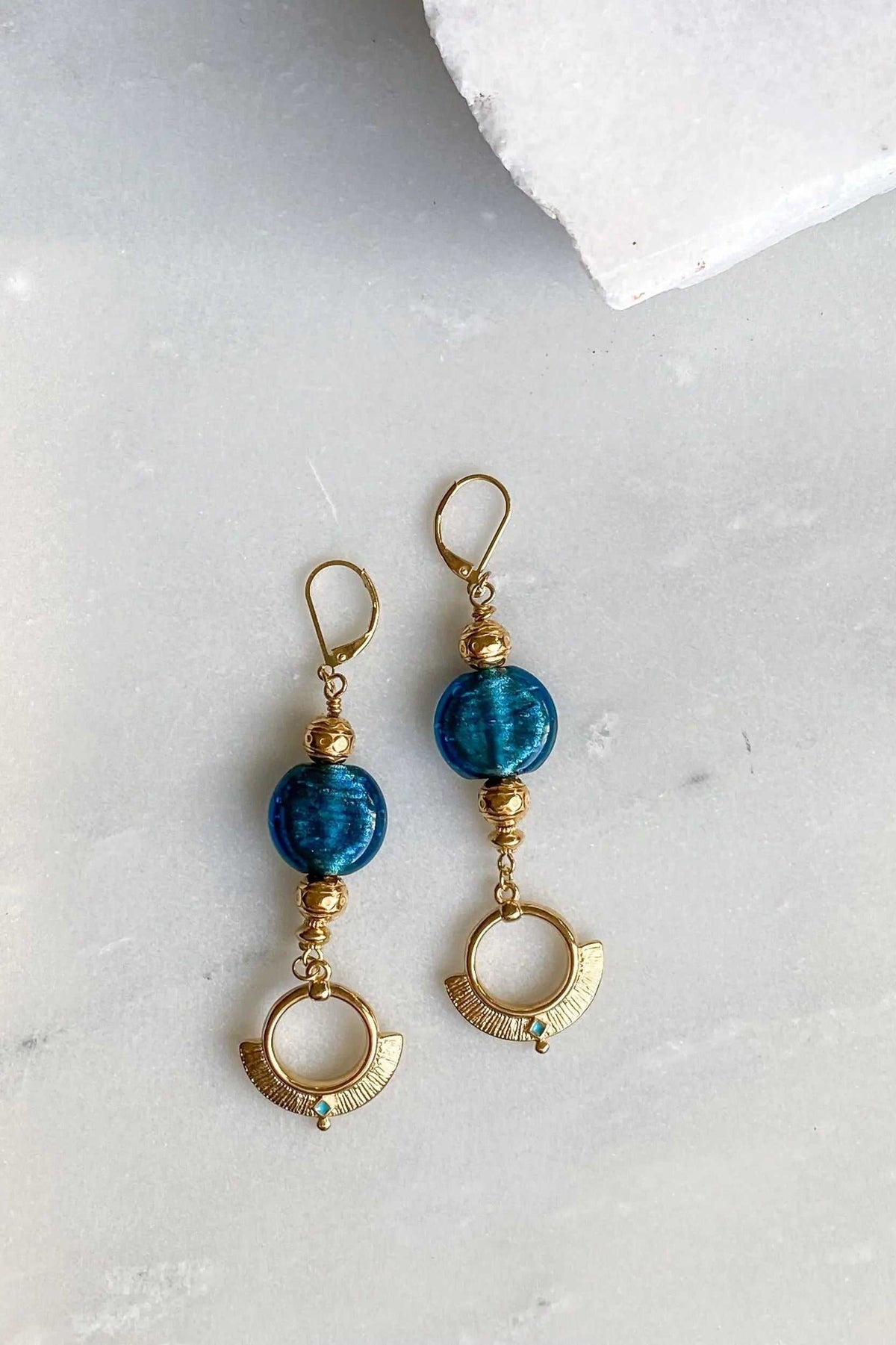 Statement Crystal Earrings with gold-tone metal, vivid blue round glass stones, and crescent-shaped drops with tiny crystals