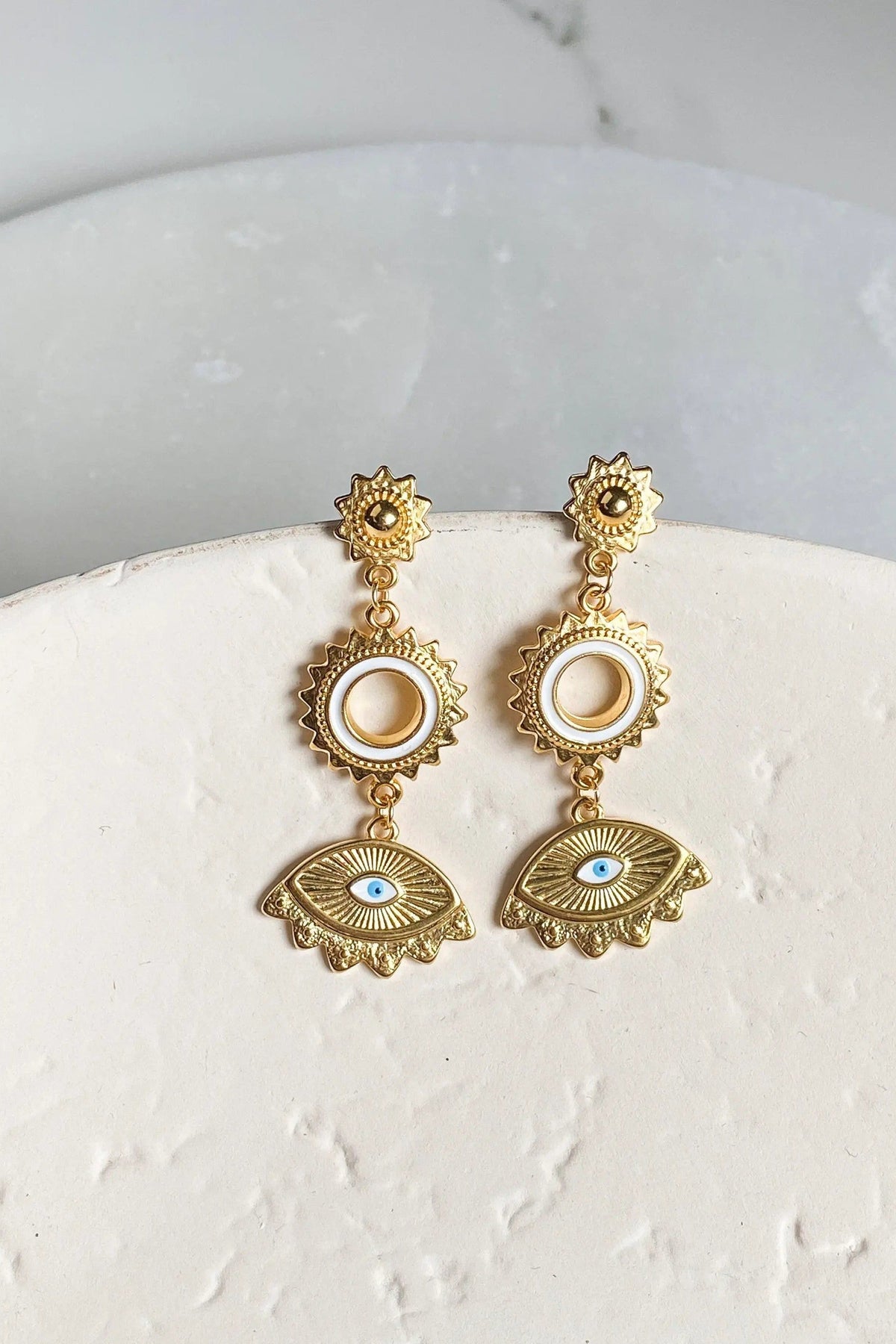 Statement evil eye earrings in gold-tone metal, with dangling sunburst and circular motifs and blue enamel eye charms
