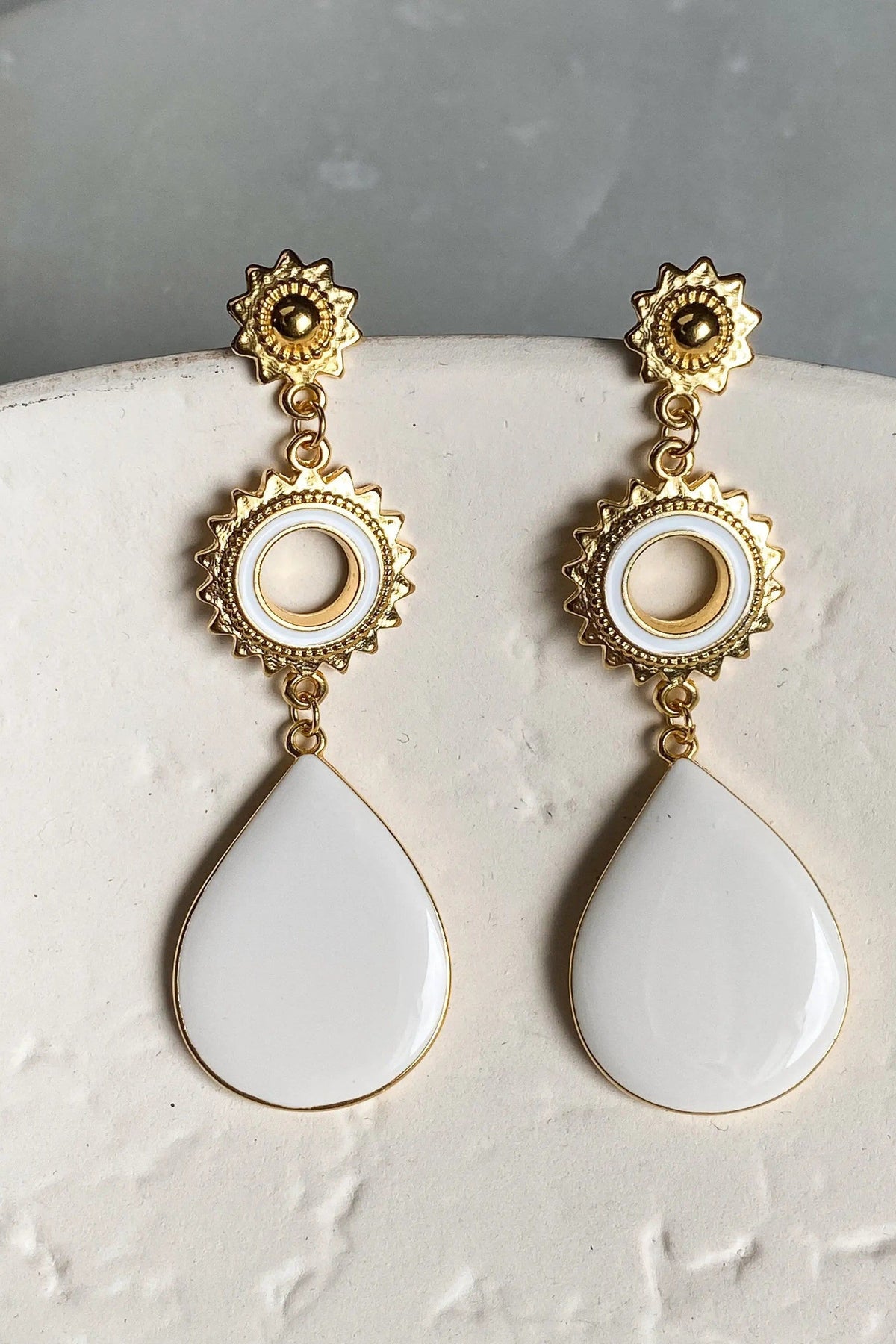 Statement evil eye earrings in gold-tone metal with ornate sunburst accents, white enamel circular eyes and teardrop drops