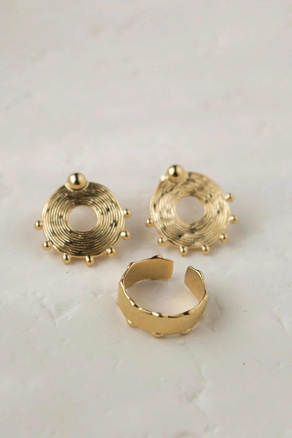 Statement Gold plated ring with a smooth, wide open band and adjustable design, shown with matching round spiral earrings