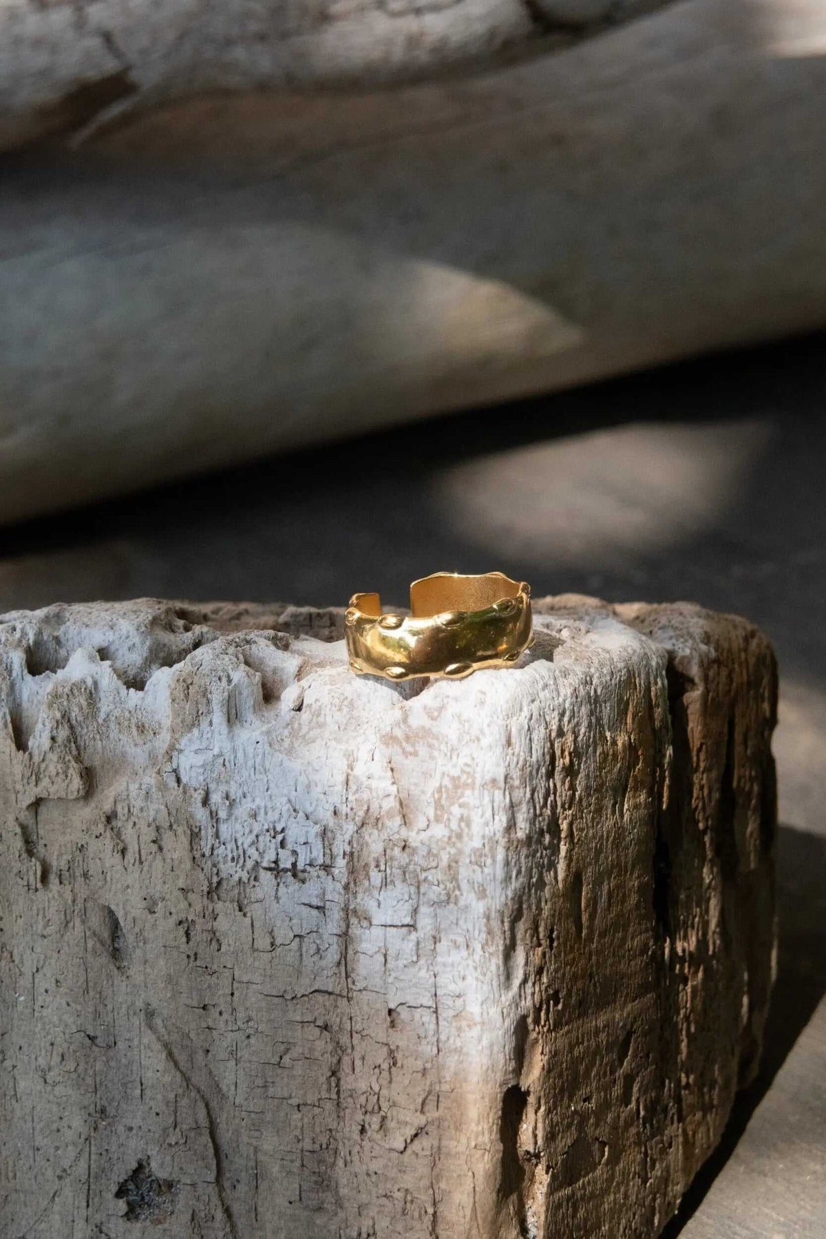 Statement Gold plated ring in bright gold-tone metal, featuring a wide irregular band with a sculptural, wavy edge