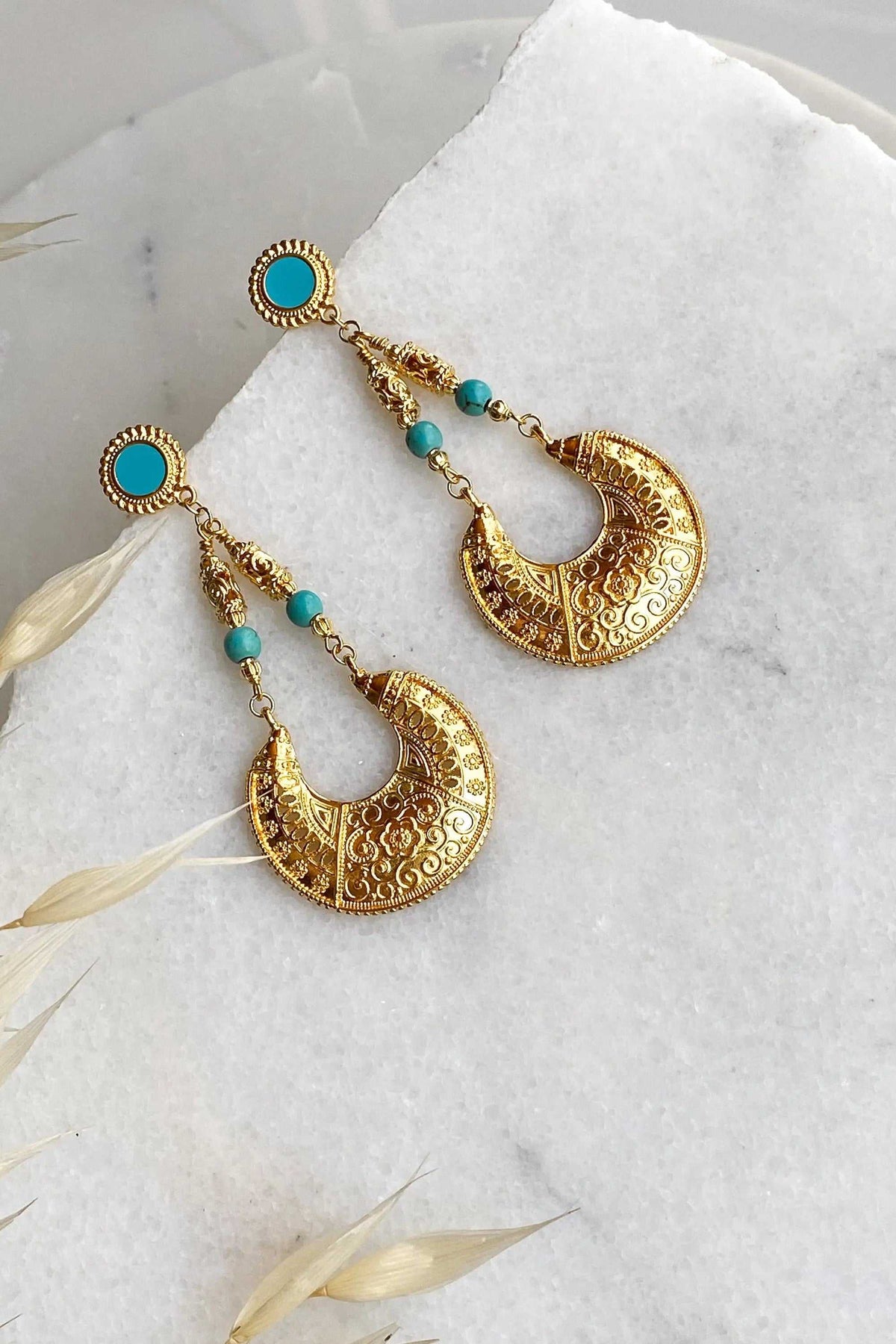 Statement oversize earrings in gold-tone metal with turquoise beads and ornate engraved crescent-shaped drops