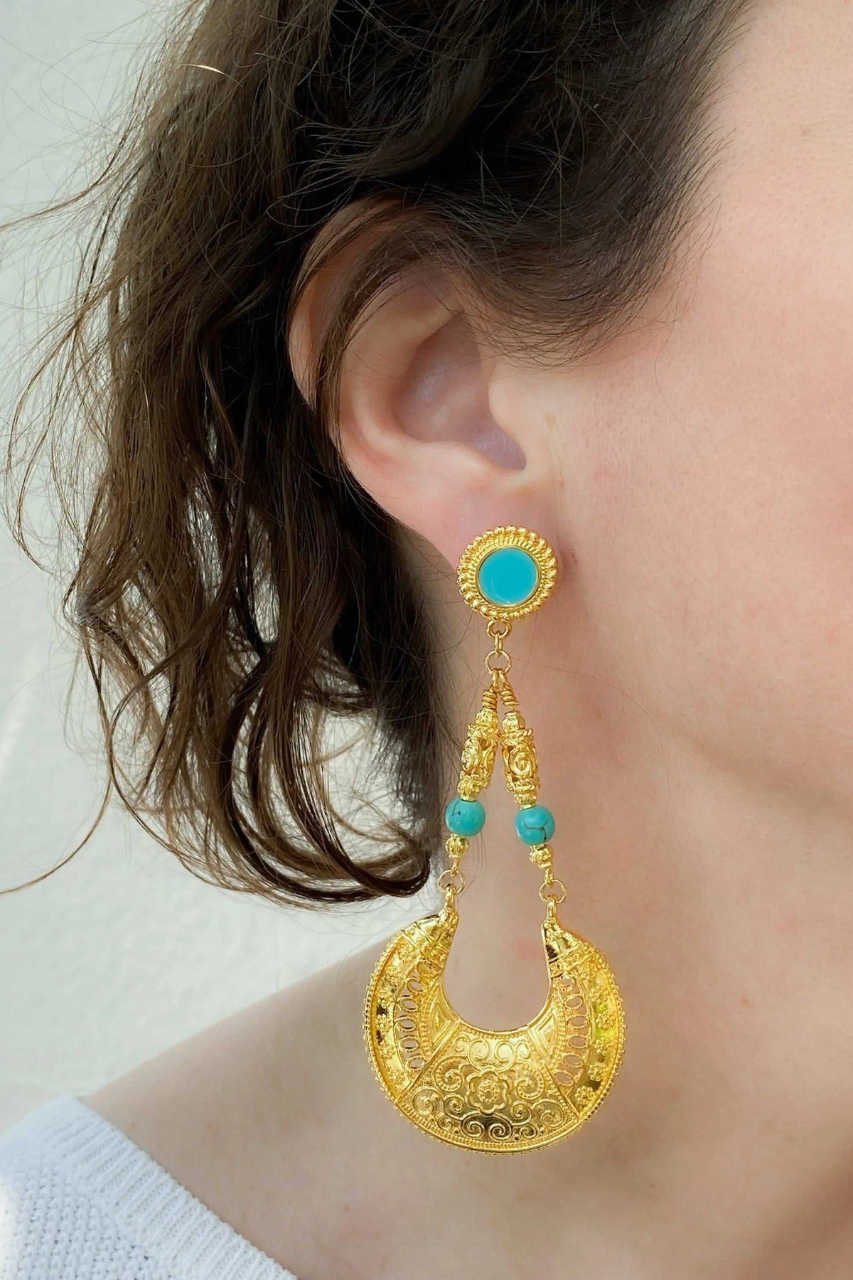 Statement oversize earrings in gold-tone metal with turquoise stones and ornate circular drop design