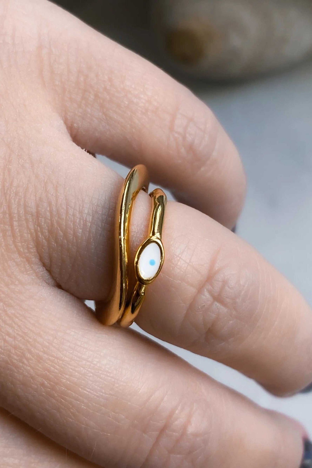 Thick Gold Band ring in polished gold with a slim open design and a small white oval blue-eyed charm