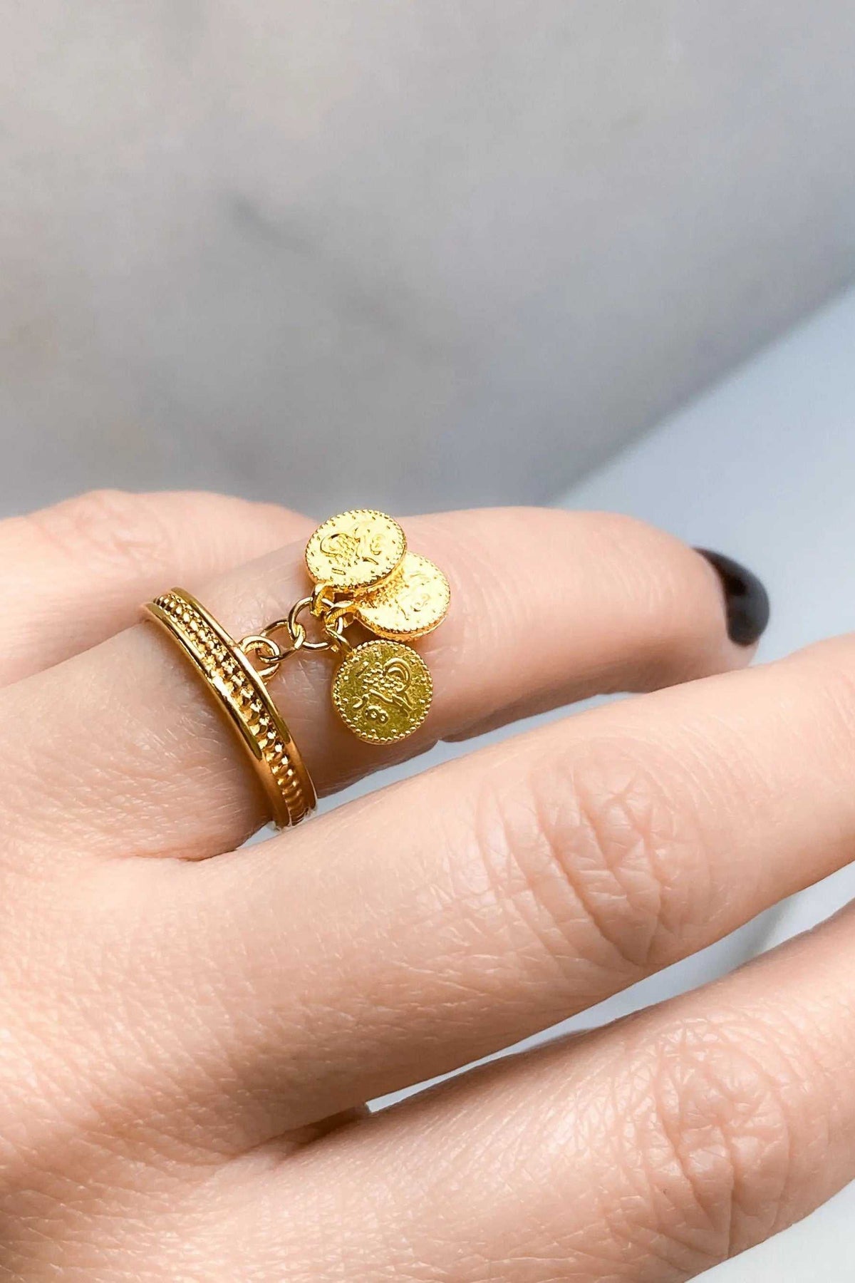 Gold-tone tiny coins ring with three textured coin charms on delicate loops and a slim ridged band