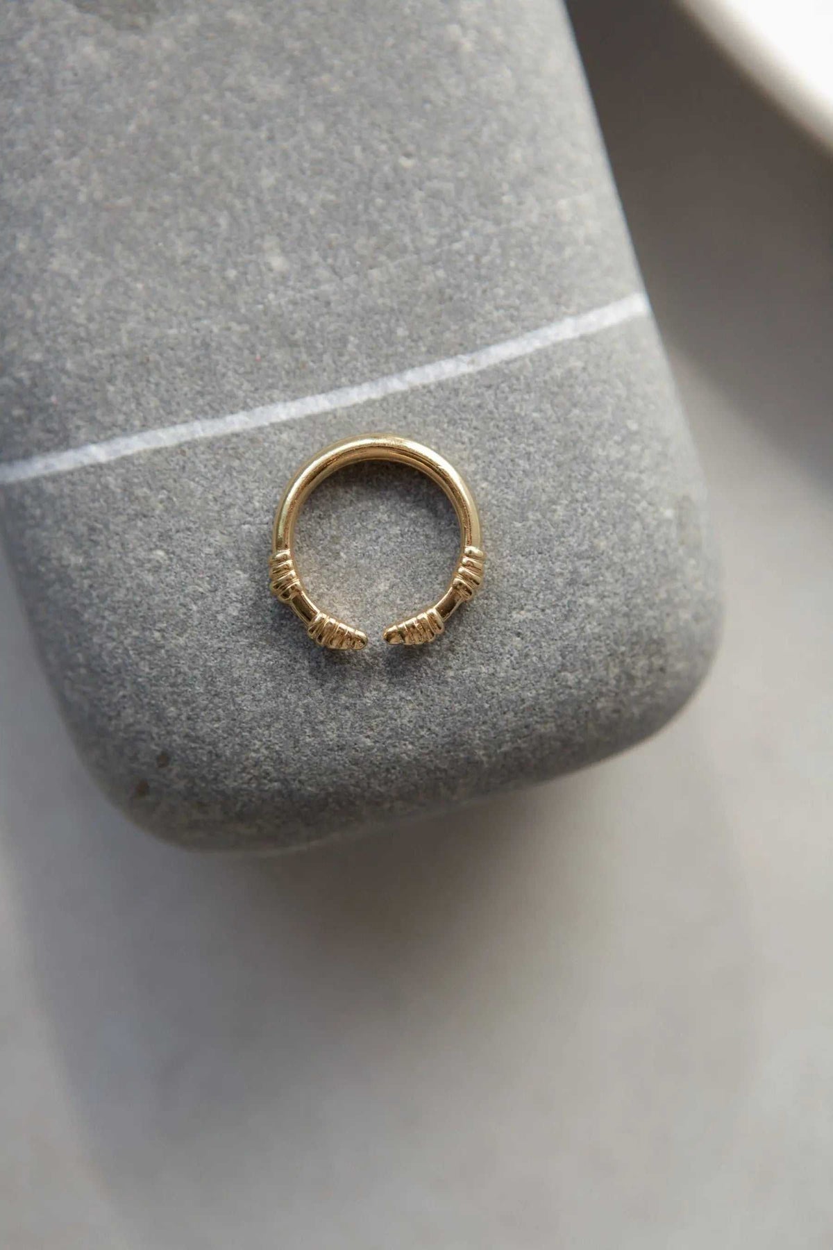 Tribal ring in gold-tone metal, a slim open band with textured wrapped ends in an adjustable design