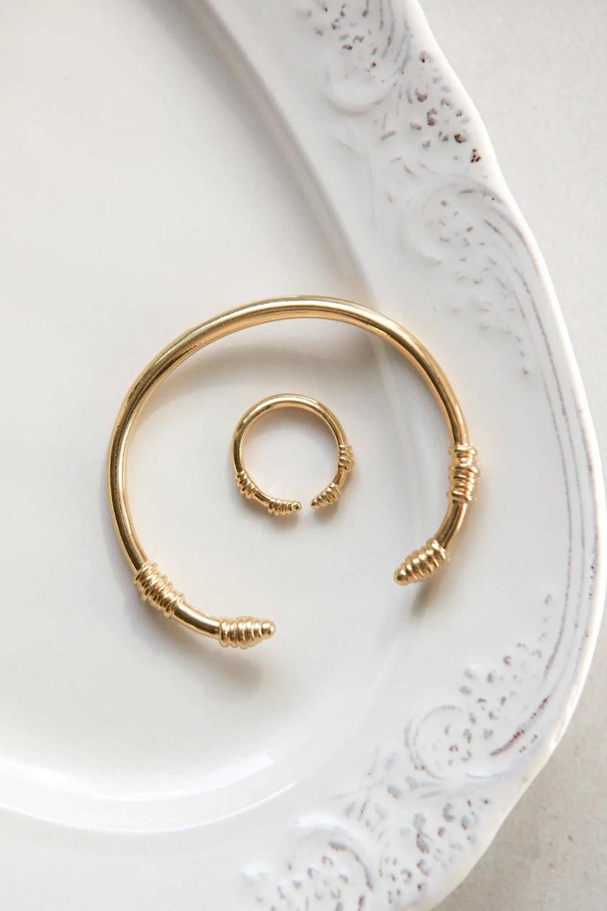 Tribal ring in gold-tone metal with a slim adjustable open band and wrapped wire details at the ends