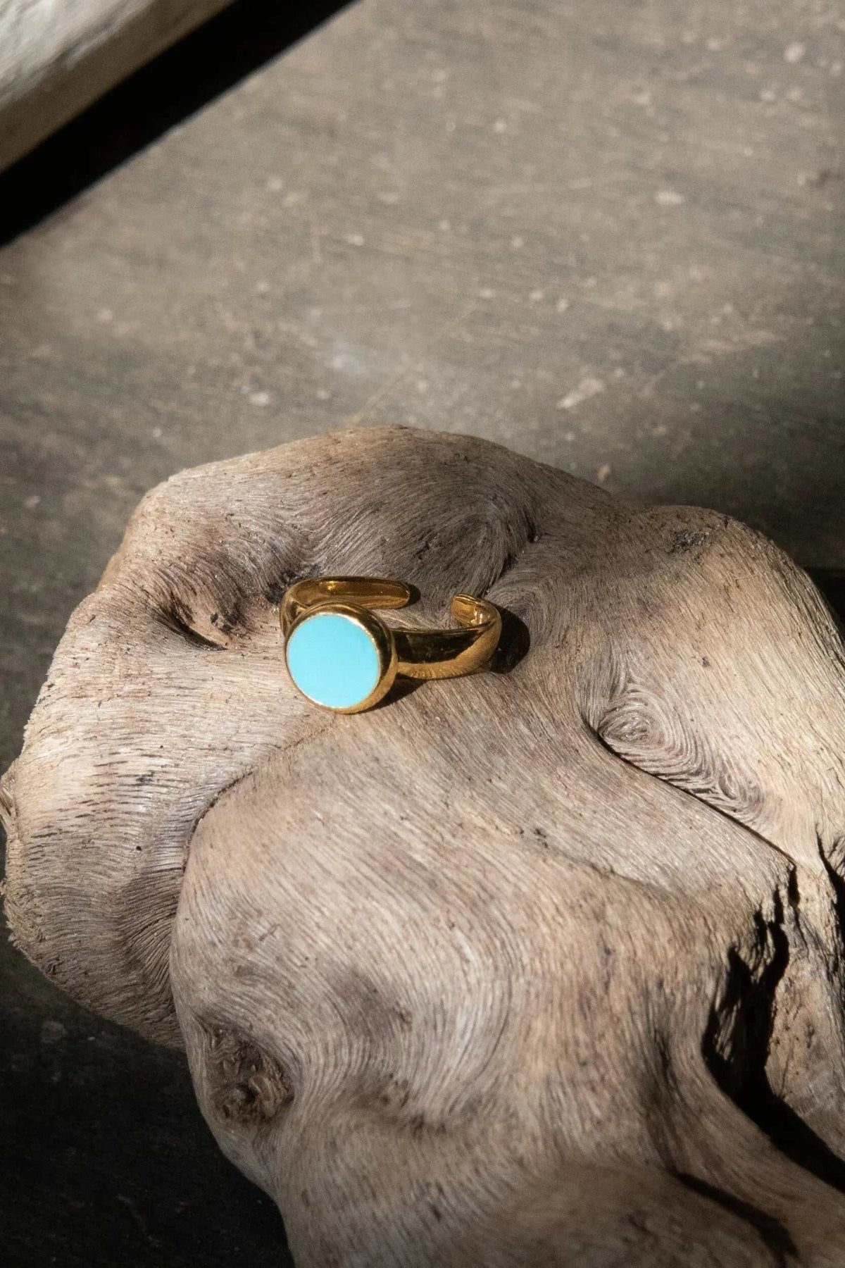 Turquoise Womens ring featuring a bright blue round stone, polished gold-tone metal, and an adjustable open band