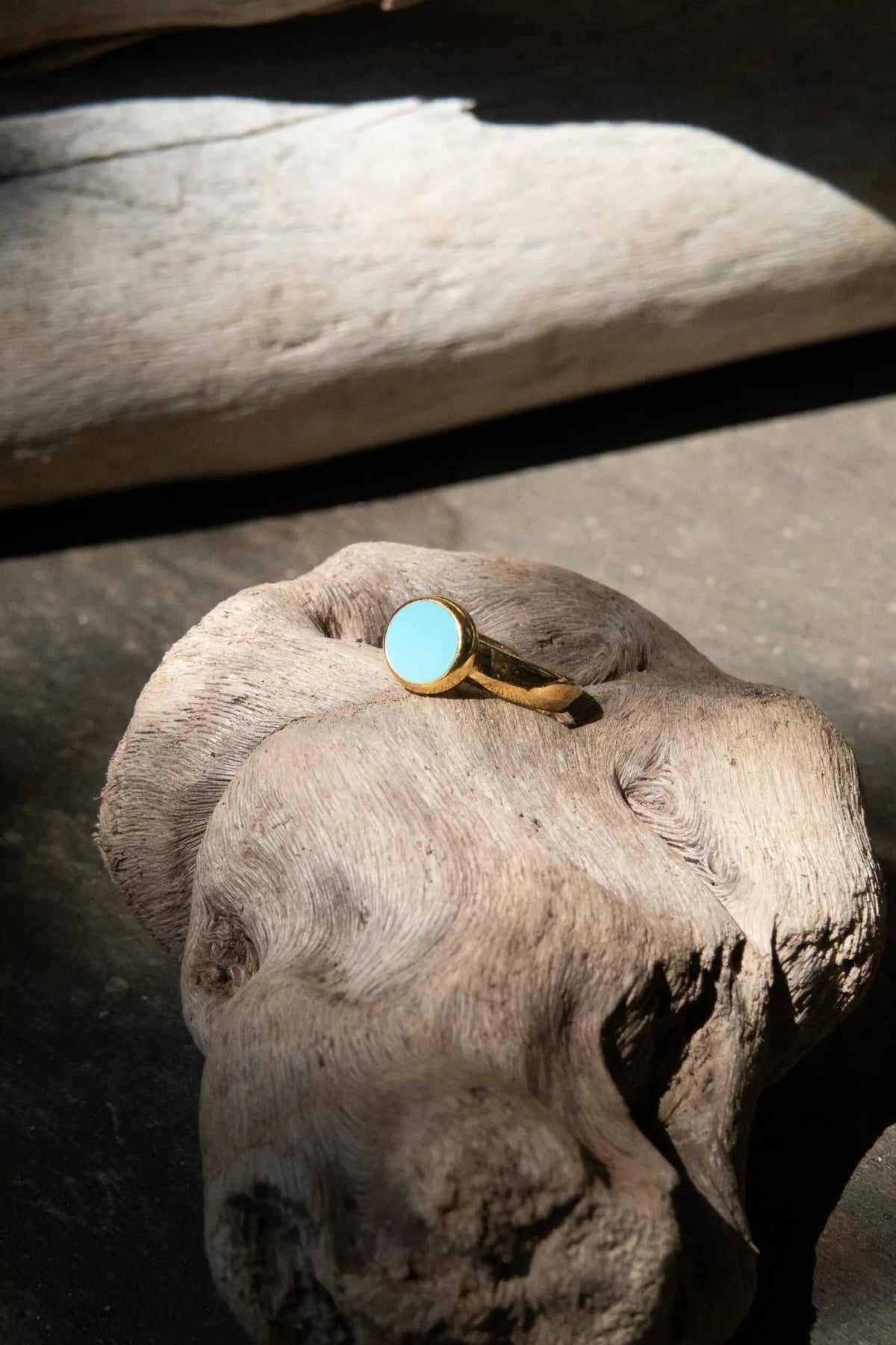 Turquoise Womens ring with a bright turquoise round stone set in a polished gold-tone band with an open design