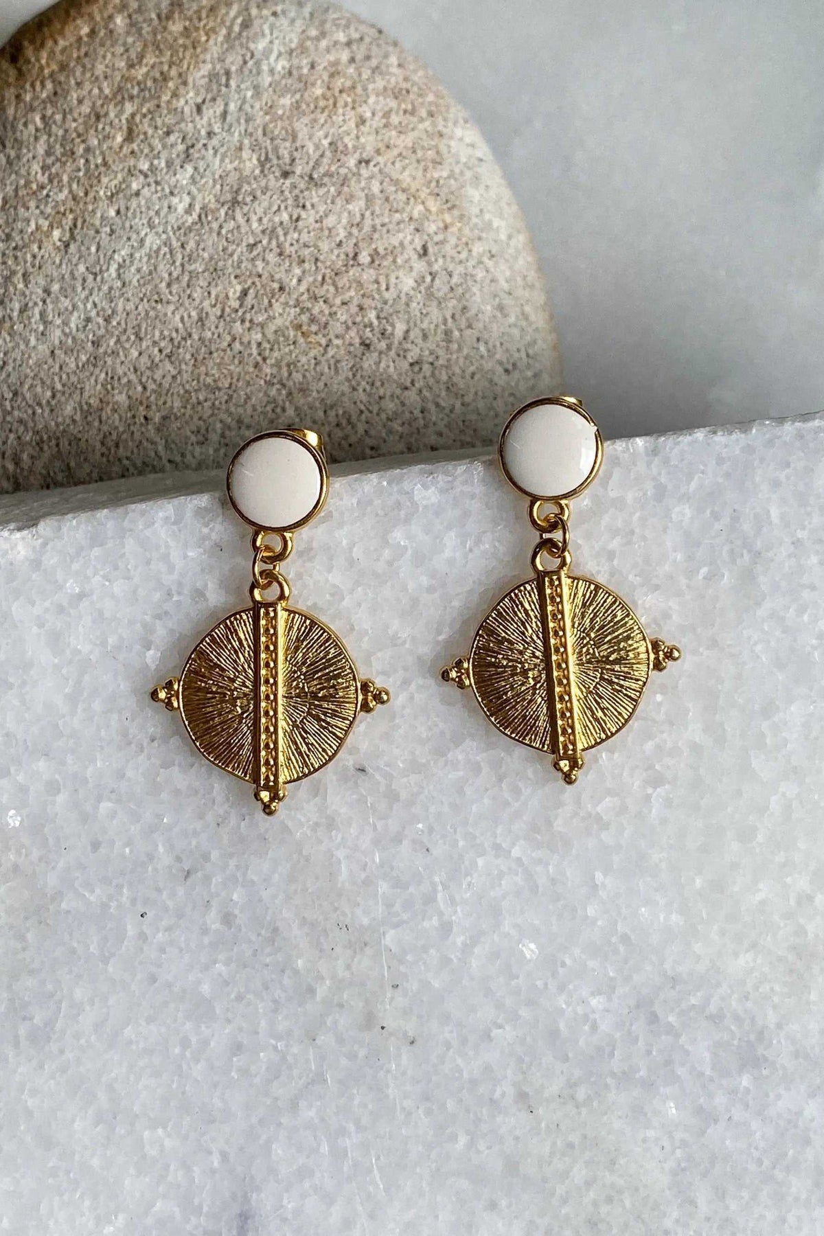 White Gold Boho earrings with white round resin studs and gold-tone circular sunburst pendants with raised center bars