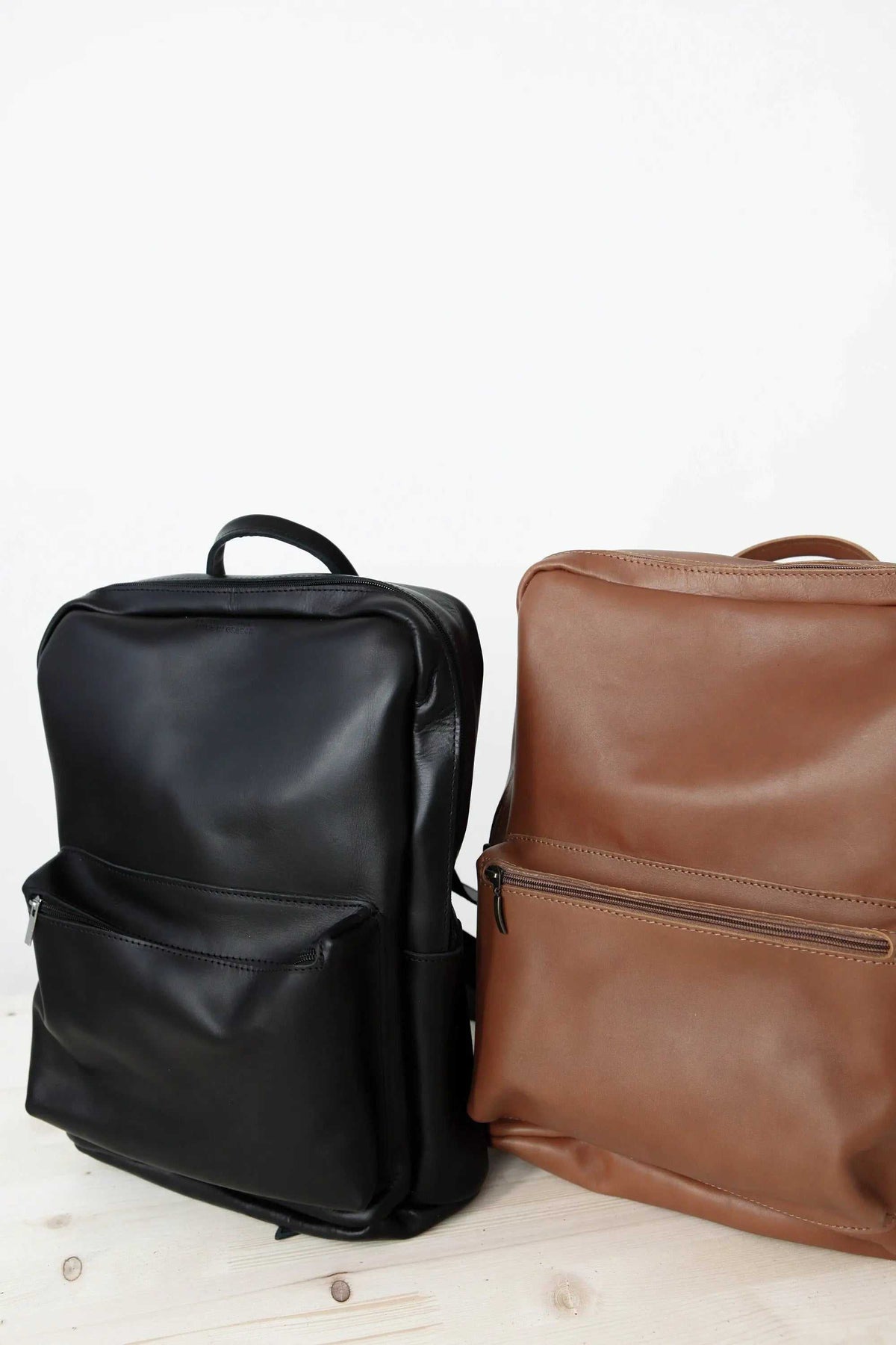 XLARGE BACKPACK in smooth black and camel leather, featuring roomy zip-front pockets, top handles and adjustable straps