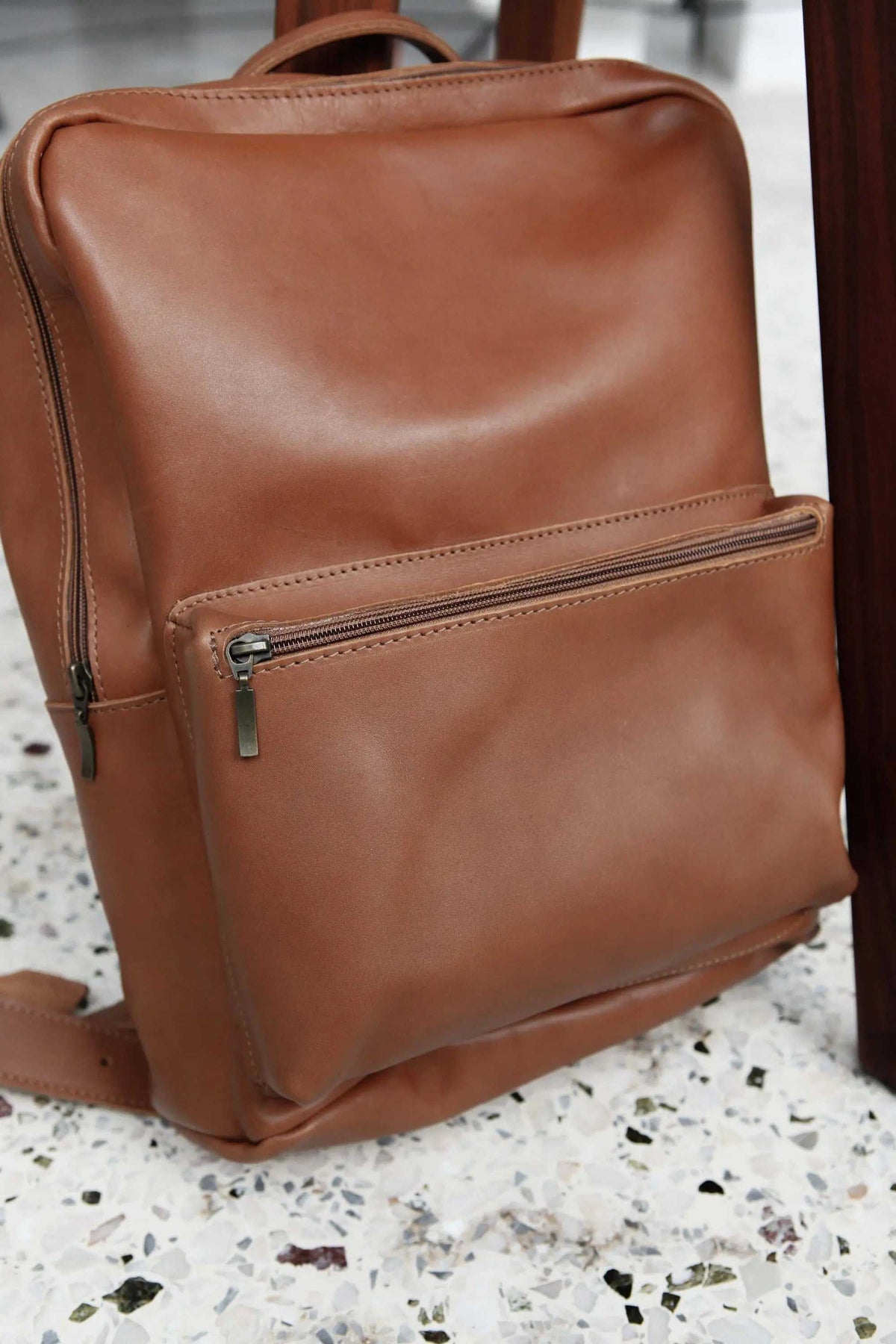 XLARGE BACKPACK in smooth camel brown leather with a zippered front pocket, top handle and backpack straps