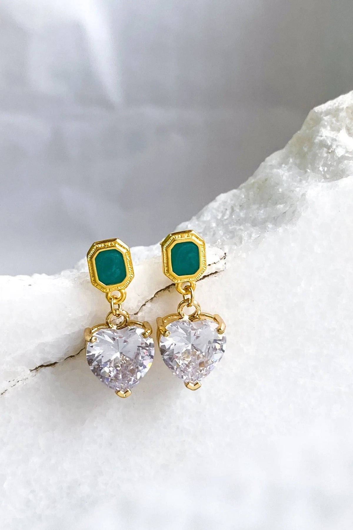 Zircon Heart Earrings with faceted clear heart-shaped stones, gold-tone settings, and emerald-green rectangular studs
